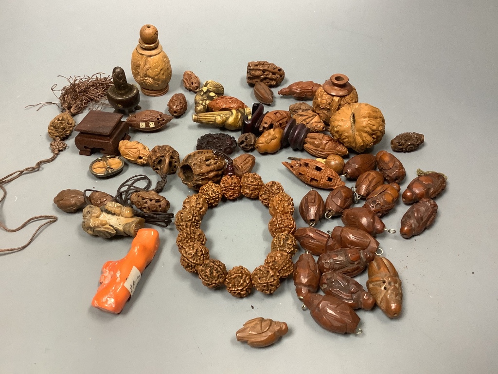 An assortment of Chinese peach stone and a nut carvings